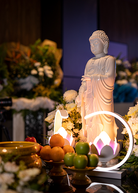Bespoke-03 A serene figure of Buddha at the altar, accompanied by lotus lamps and fruits